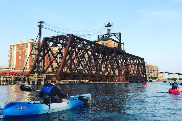 a blue and white boat parked next to a body of water