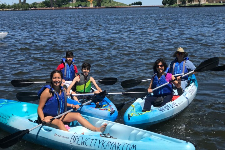 a group of people riding on the back of a boat in the water