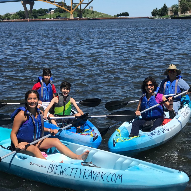 a group of people riding on the back of a boat in the water