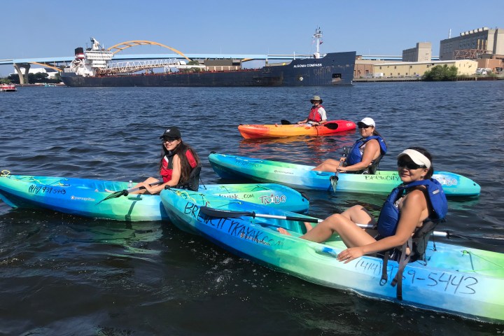 a group of people riding on the back of a boat in the water