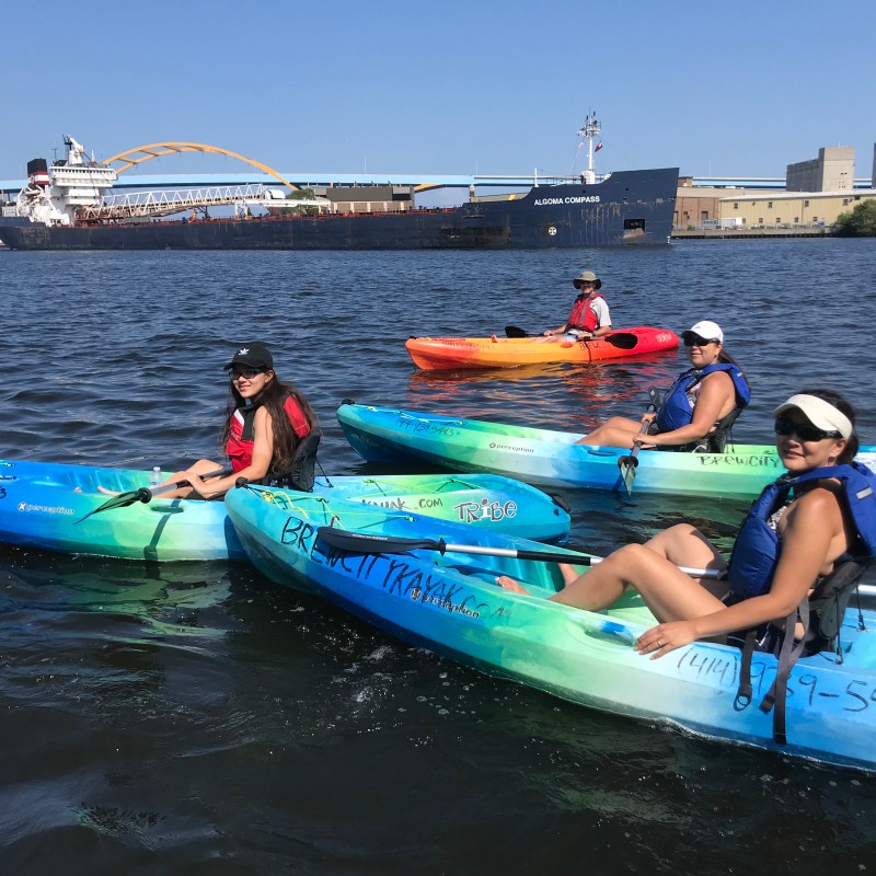 a group of people riding on the back of a boat in the water